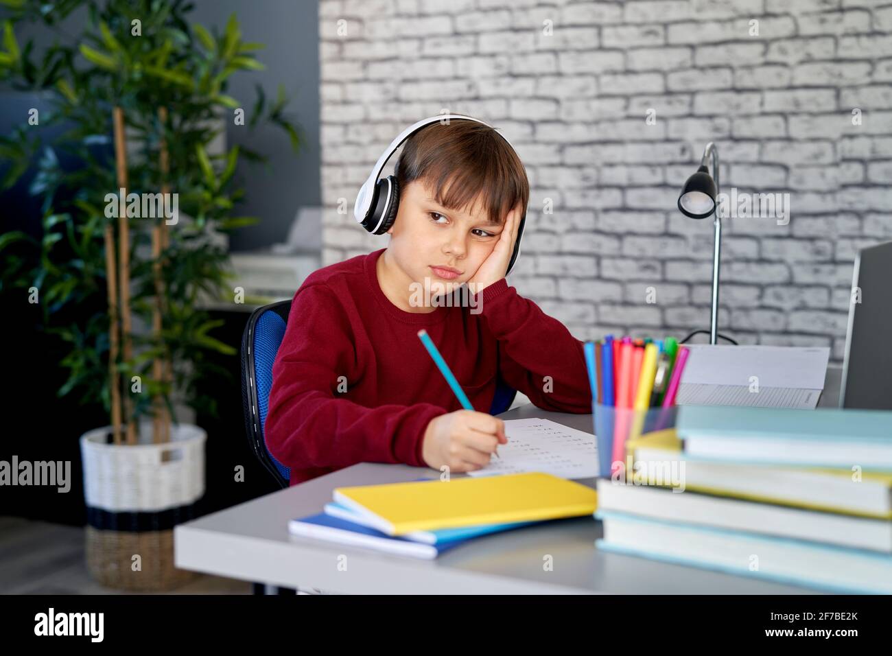 Boy ist mit Hausaufgaben zu Hause gelangweilt Stockfoto