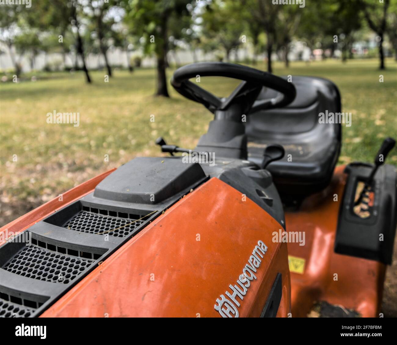 Ho Chi Minh City, 16. März 2021: Gebrauchte orange Reiten Rasenmäher auf dem Gras im Park, Nahaufnahme. Stockfoto