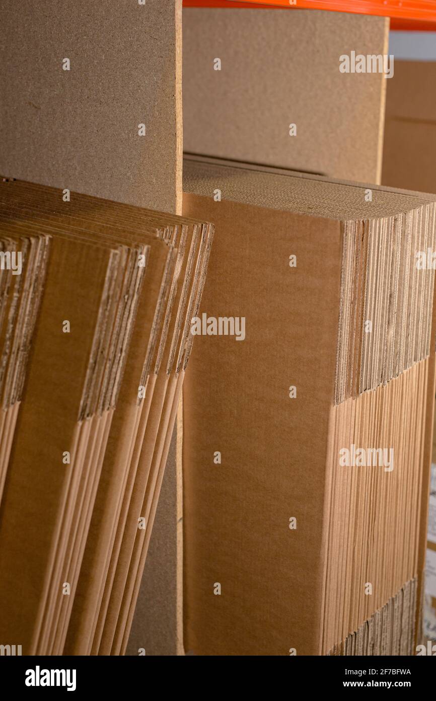 Eine Auswahl flacher Versandkartons/Kartons auf einem Regal, das fertig verpackt und mit dem Produkt verpackt werden kann. Lager, Versand, Versand, Paketkonzept Stockfoto