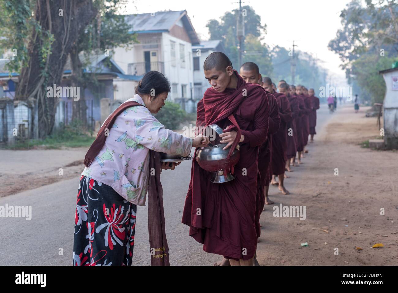 Mönche, die in den Straßen von Bago spazieren und Lebensmittelspenden sammeln, Bago, Myanmar Stockfoto