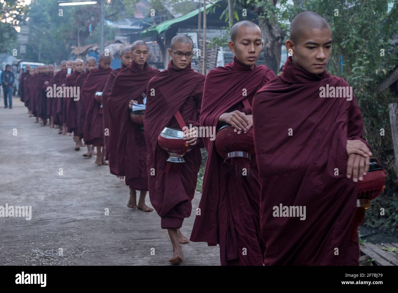 Mönche, die in den Straßen von Bago spazieren und Lebensmittelspenden sammeln, Bago, Myanmar Stockfoto