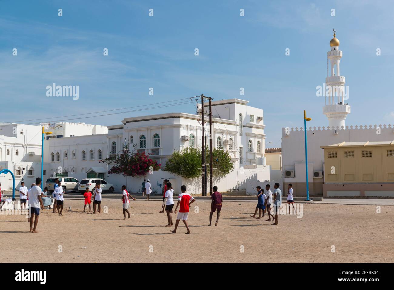 Jungen, die auf einem offenen Platz im Dorf Ayjah in der Nähe von Sur Fußball spielen. Oman. Stockfoto