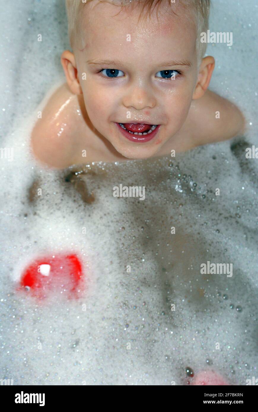 Drei Jahre alter Junge, der in einer Badewanne sitzt Stockfoto