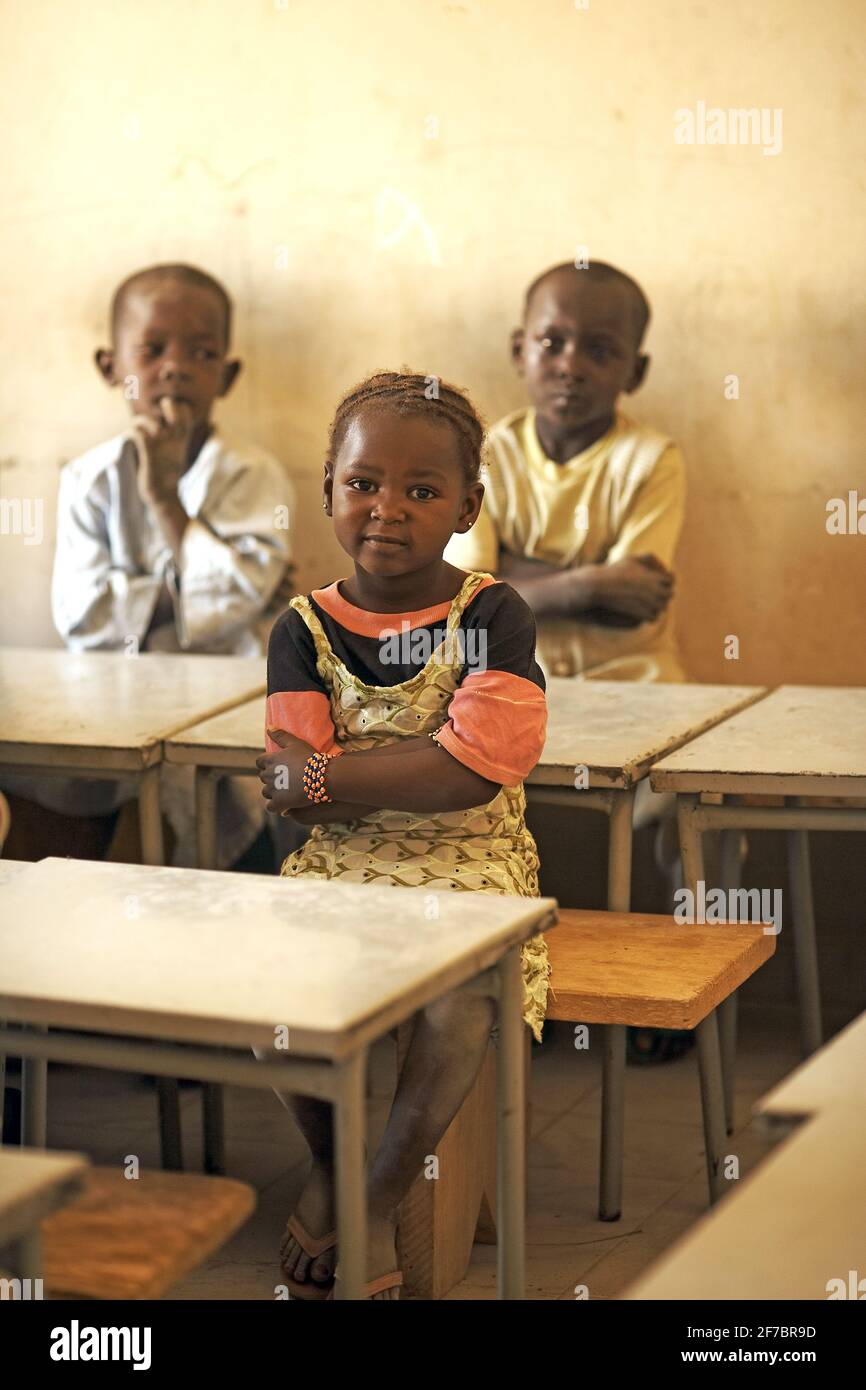 Kinder sitzen in einem Klassenzimmer in Mali, Westafrika, auf Schreibtischen. Stockfoto