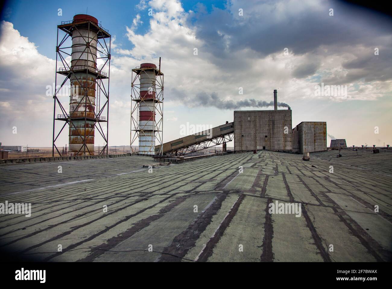 Veraltete sowjetische Bergbau- und Verarbeitungsanlage. Rauchstapel auf dem Dach und Industriegebäude im Hintergrund. Stockfoto
