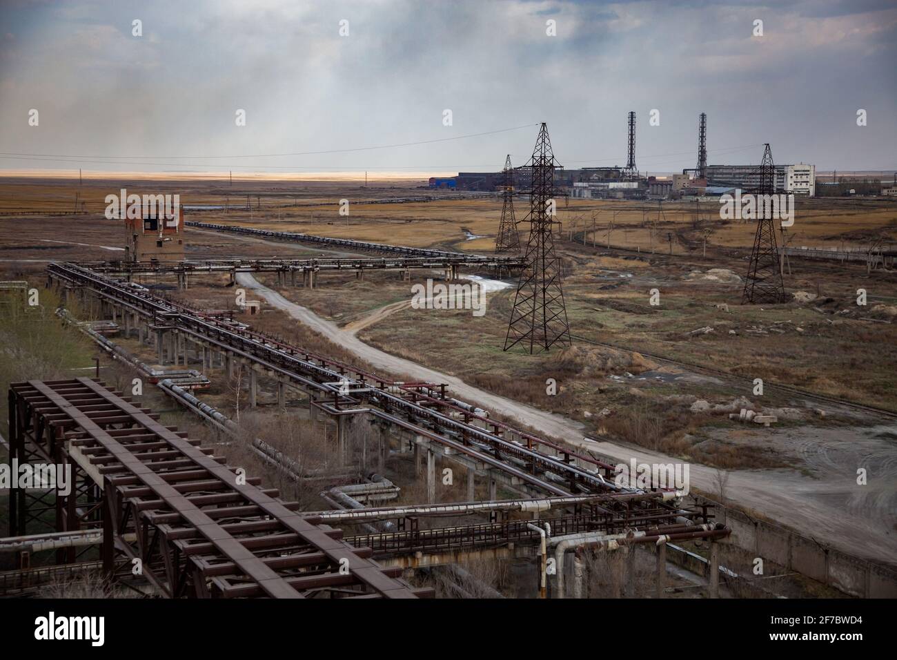 Veraltete sowjetische Bergbau- und Verarbeitungsfabrik. Panoramaansicht. Rohrleitungen an der Vorderseite. Rauch stapelt sich oh Horizont. Stockfoto