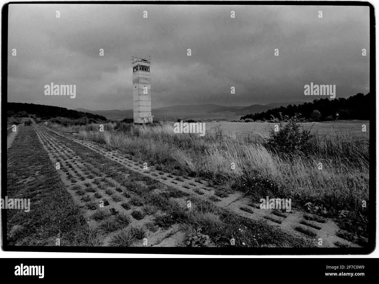 Deutschland 1994 Fulda Gap Point Alpha 1994 Panzergleise auf der ehemaligen Ostseite der Grenze und ostdeutscher Aussichtsturm mit Blick nach Westen. Die Fulda-Lücke, ein Gebiet zwischen der Hessen-Thüringer Grenze (ehemalige innerdeutsche Grenze) und Frankfurt am Main, Es enthält zwei Tieflandkorridore, durch die Panzer bei einem überraschenden Angriff der Sowjets und ihrer Verbündeten des Warschauer Paktes gefahren sein könnten, um die Überquerung des Rheins zu erreichen.[1] die nach Fulda benannte Fuldaer Lücke wurde während des Kalten Krieges von 1947-1991 als strategisch wichtig angesehen Stockfoto