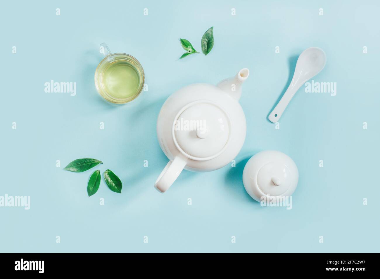 Blick von oben auf eine Reihe von Teegeschirr Teekanne Zucker Schüssel Tasse mit Tee auf blauem Hintergrund Stockfoto