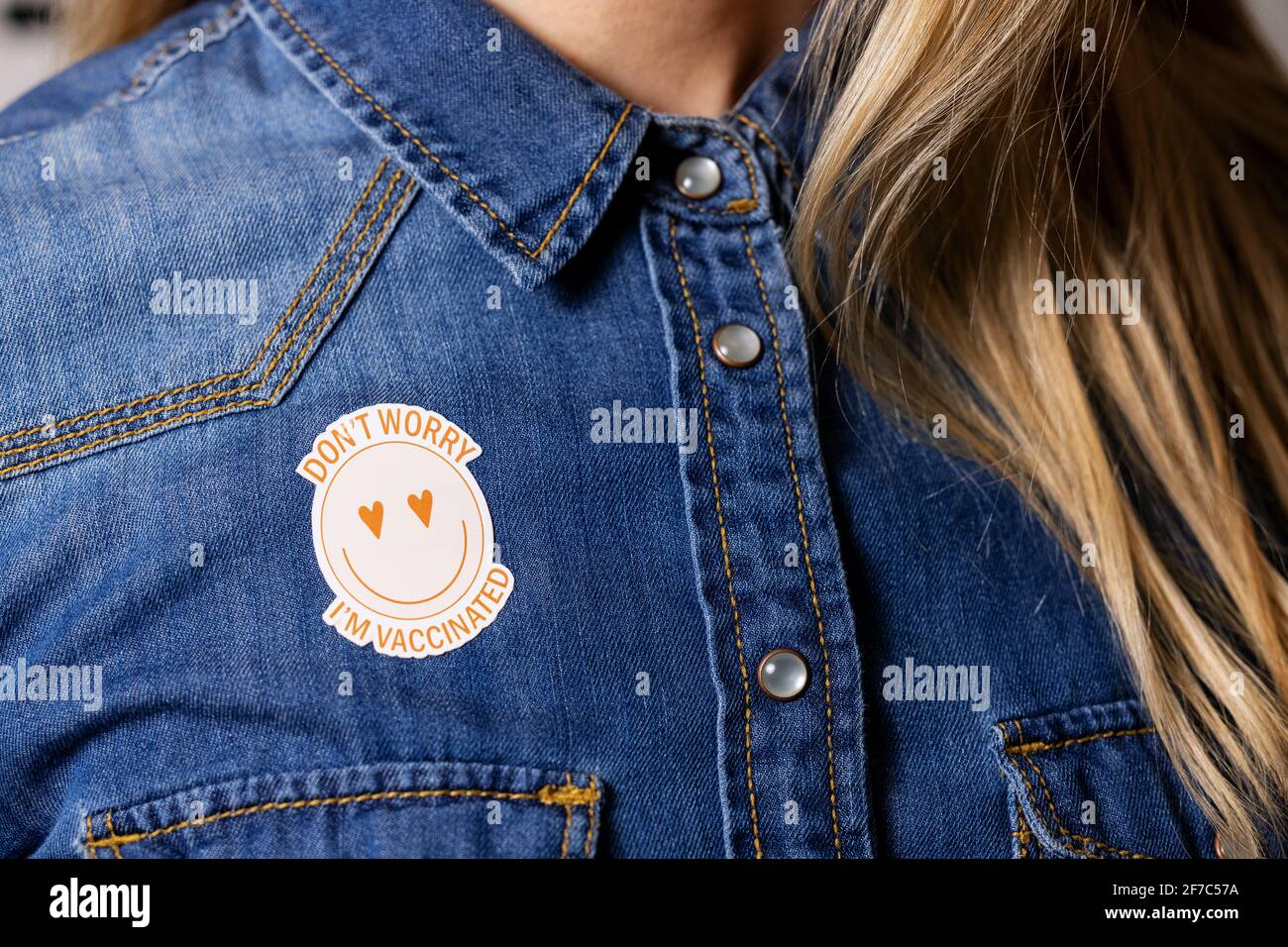 Geimpfte Person mit Immunitätskennzeichnung auf dem Hemd Stockfoto