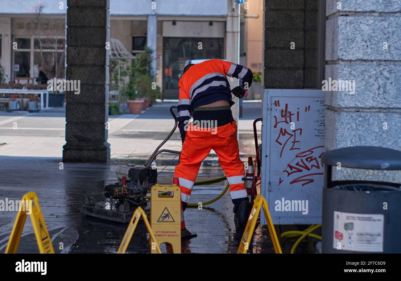 Italienischer Arbeiter in Aktion Waschen eines öffentlichen Bereichs in Lecco, Lombardei, Italien. Stockfoto