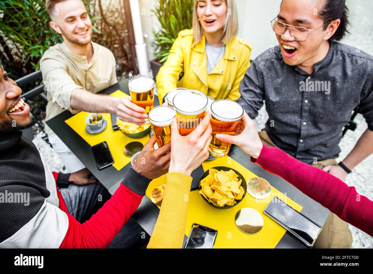 Gruppe multikultureller Freunde, die in der Brauerei Bier trinken und toasten Bar-Restaurant - Glückliche Menschen, die Spaß auf dem Dach haben Party - Fokus auf Brille Stockfoto