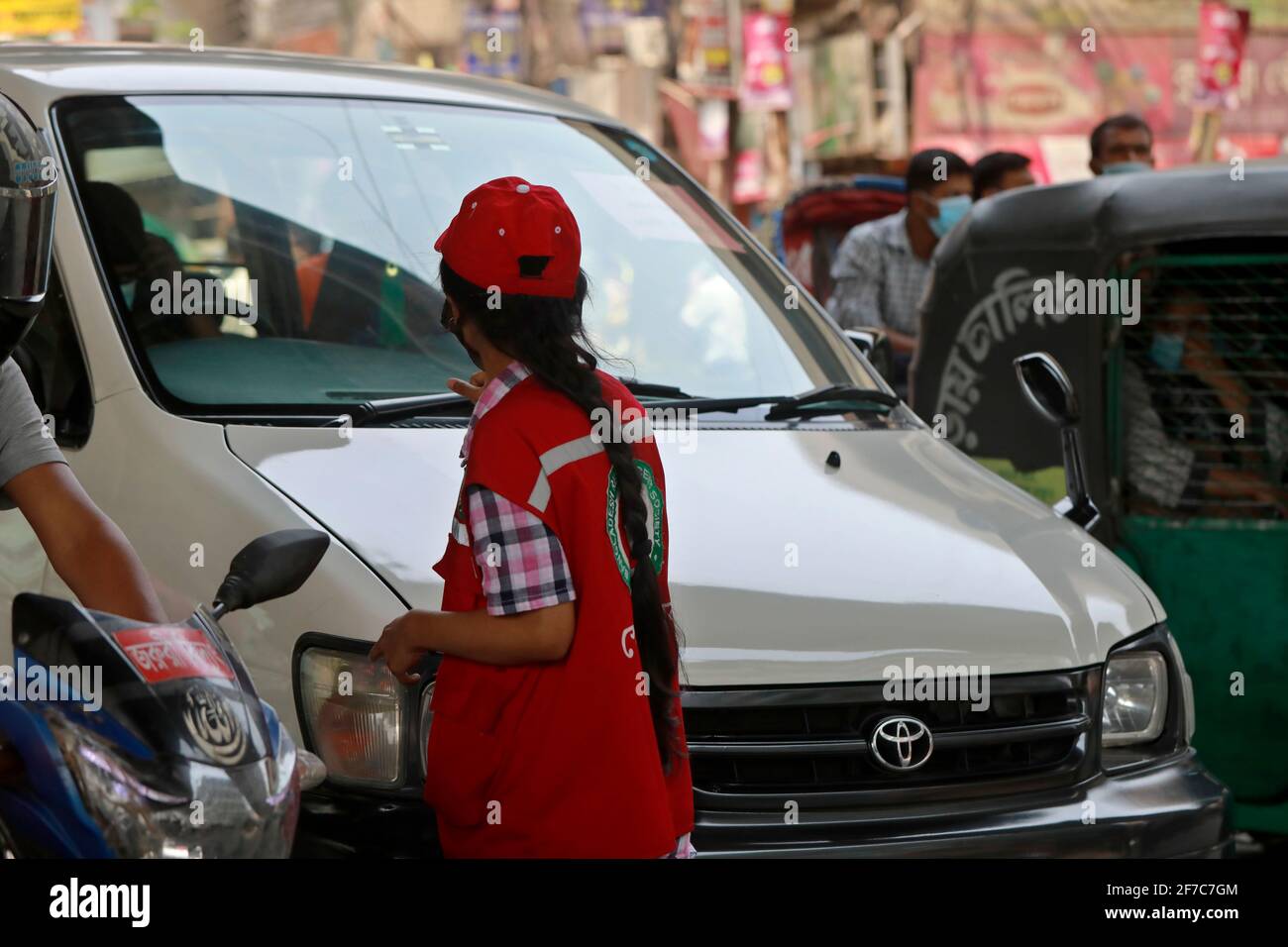 Dhaka, Bangladesch - 06. April 2021: Freiwillige der Red Crescent Society warnen Fußgänger vor dem Tragen von Masken im Maghbazar in Dhaka, dem zweiten d Stockfoto