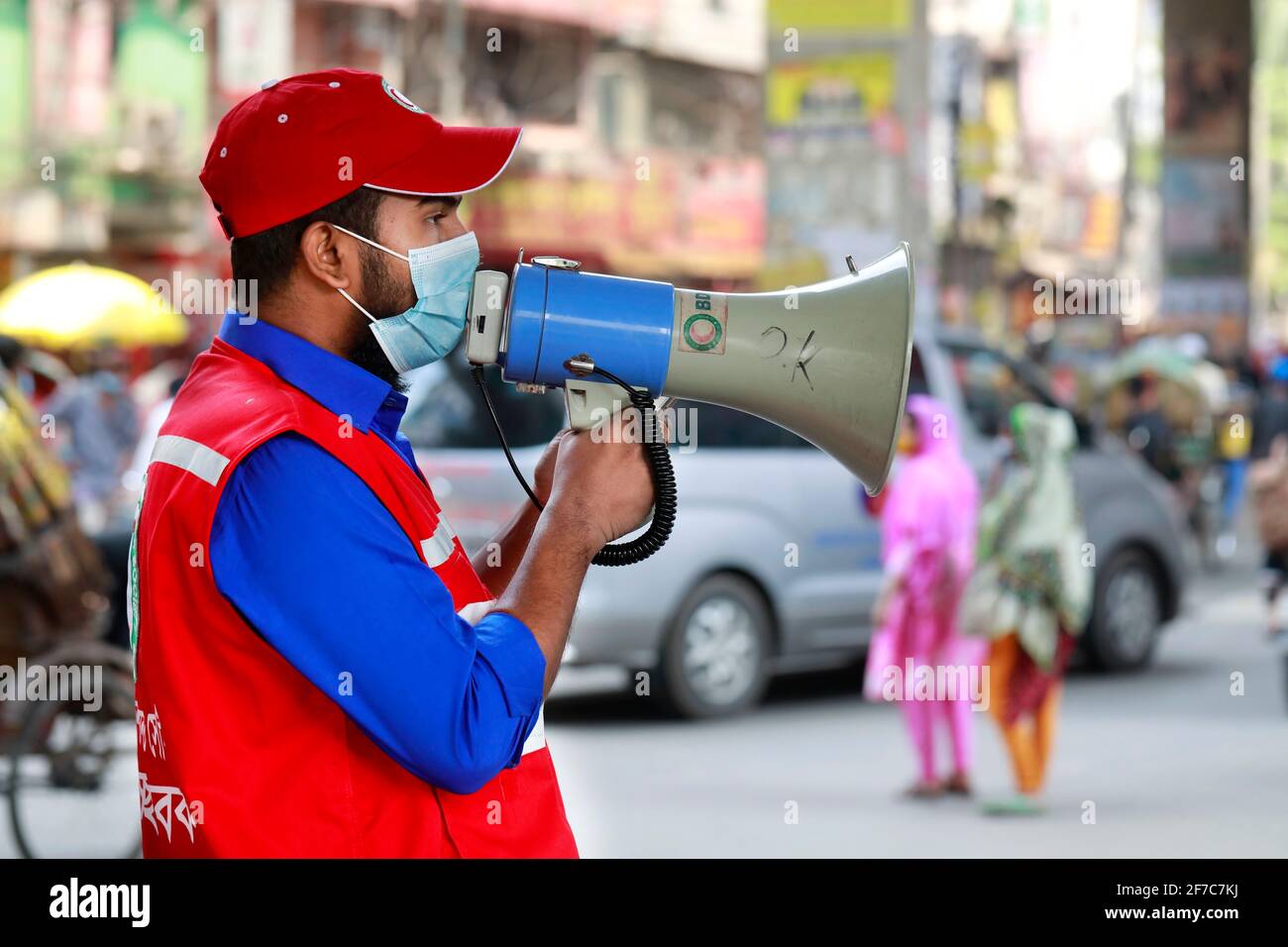 Dhaka, Bangladesch - 06. April 2021: Freiwillige der Red Crescent Society warnen Fußgänger vor dem Tragen von Masken im Maghbazar in Dhaka, dem zweiten d Stockfoto