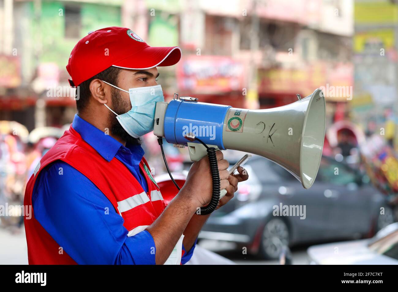 Dhaka, Bangladesch - 06. April 2021: Freiwillige der Red Crescent Society warnen Fußgänger vor dem Tragen von Masken im Maghbazar in Dhaka, dem zweiten d Stockfoto