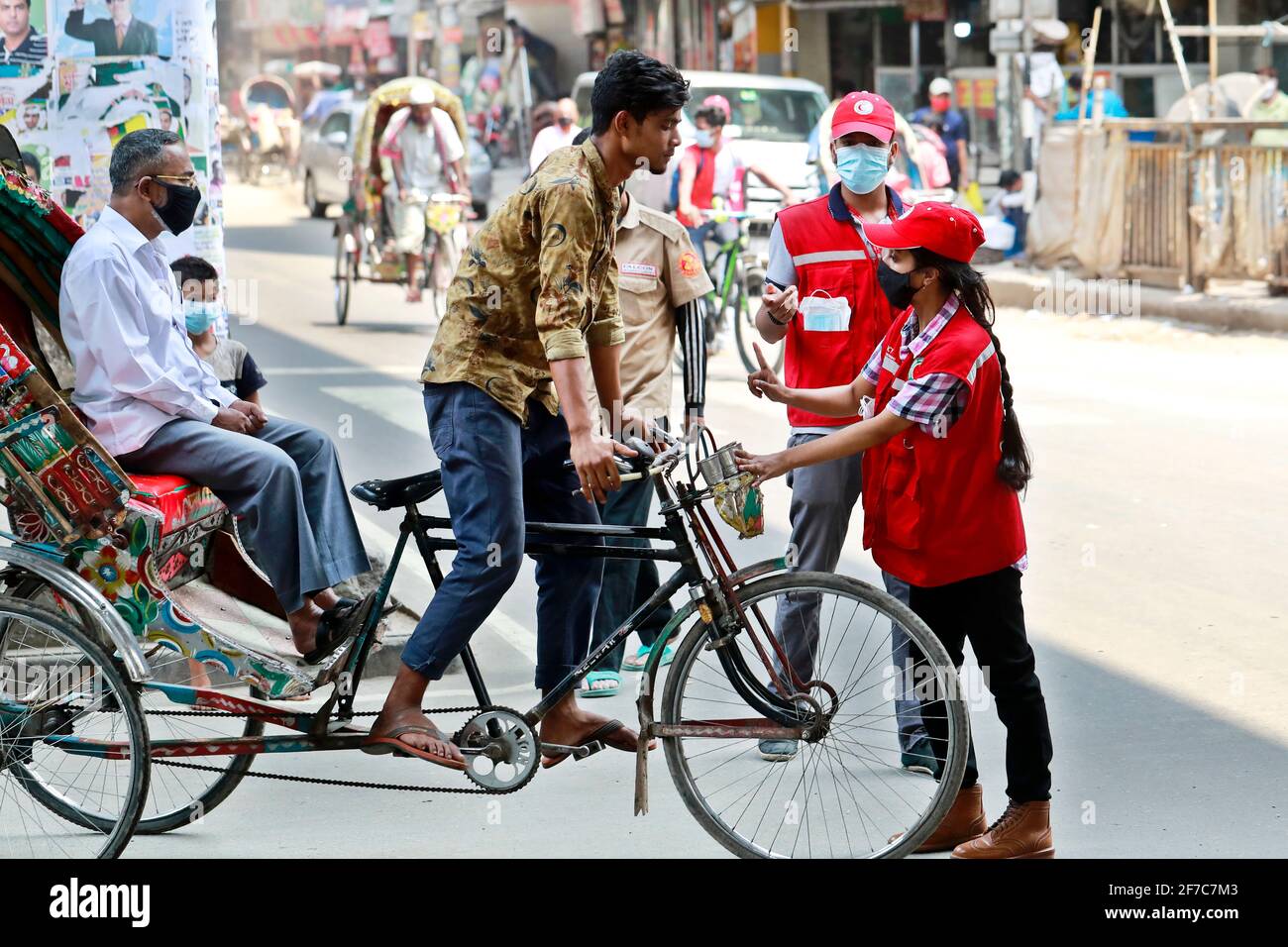 Dhaka, Bangladesch - 06. April 2021: Freiwillige der Red Crescent Society warnen Fußgänger vor dem Tragen von Masken im Maghbazar in Dhaka, dem zweiten d Stockfoto