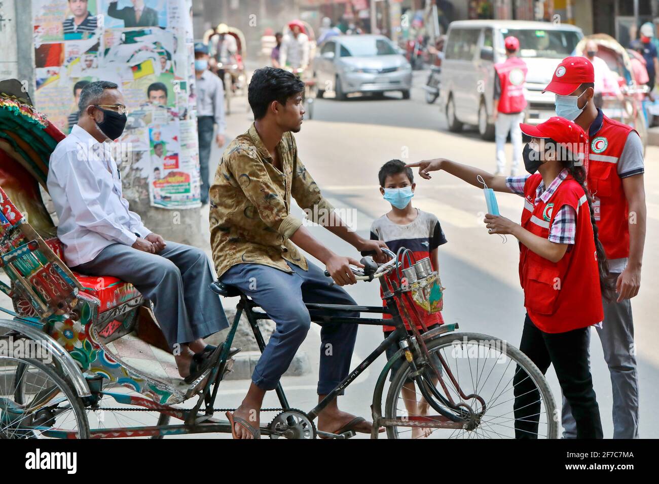 Dhaka, Bangladesch - 06. April 2021: Freiwillige der Red Crescent Society warnen Fußgänger vor dem Tragen von Masken im Maghbazar in Dhaka, dem zweiten d Stockfoto