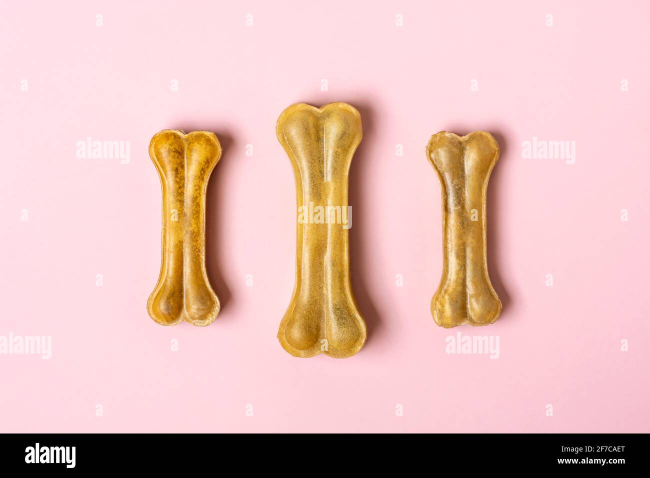 Knochen für Hunde isoliert auf rosa Hintergrund Draufsicht Flat Lay Delicious Treat für Ihr geliebtes Haustier Food for Animals Konzept. Stockfoto