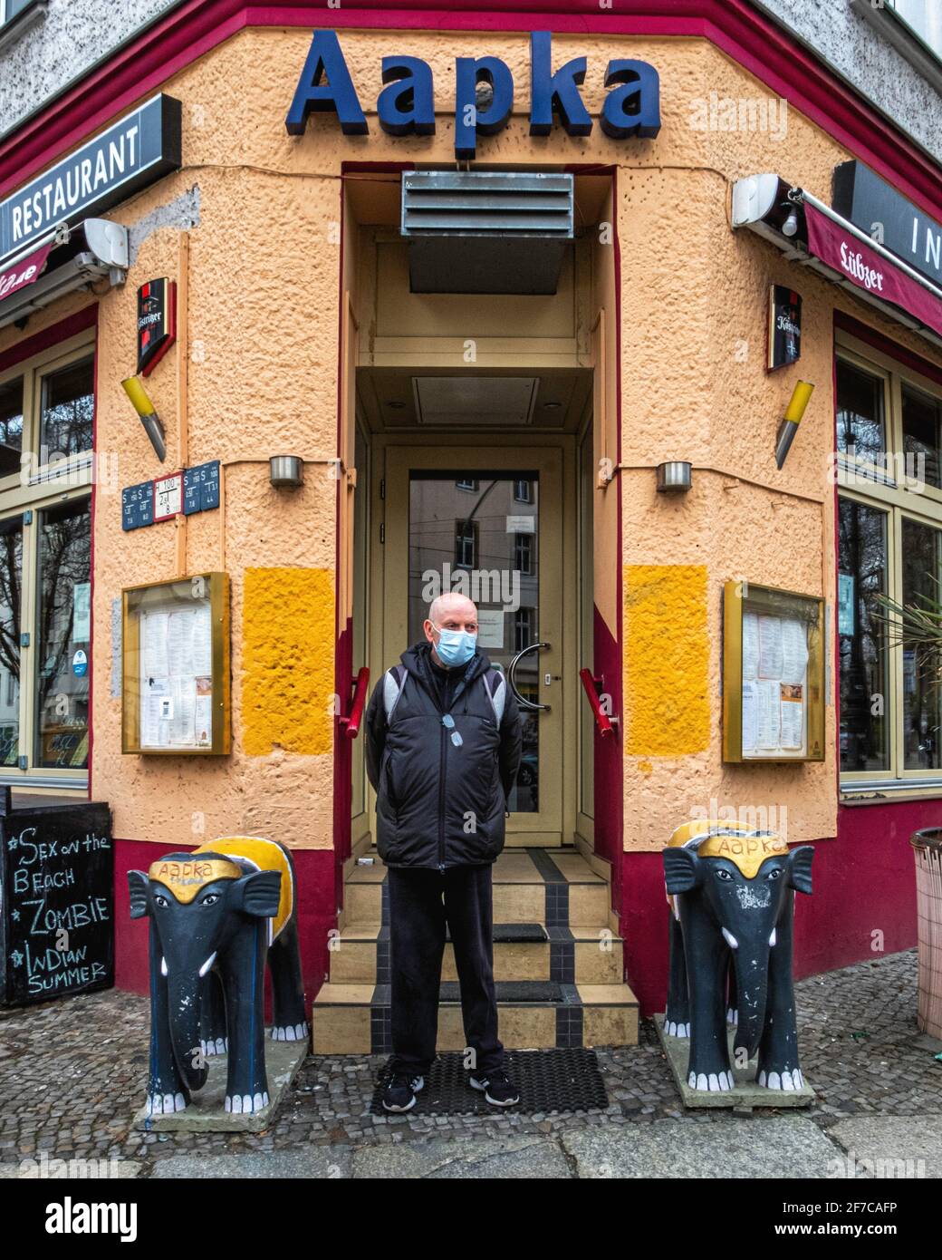Aapka Indian Restaurant Kastanienallee 50,Mitte,Berlin älterer Mann mit Maske während Corona Pandemie steht am Eingang Stockfoto