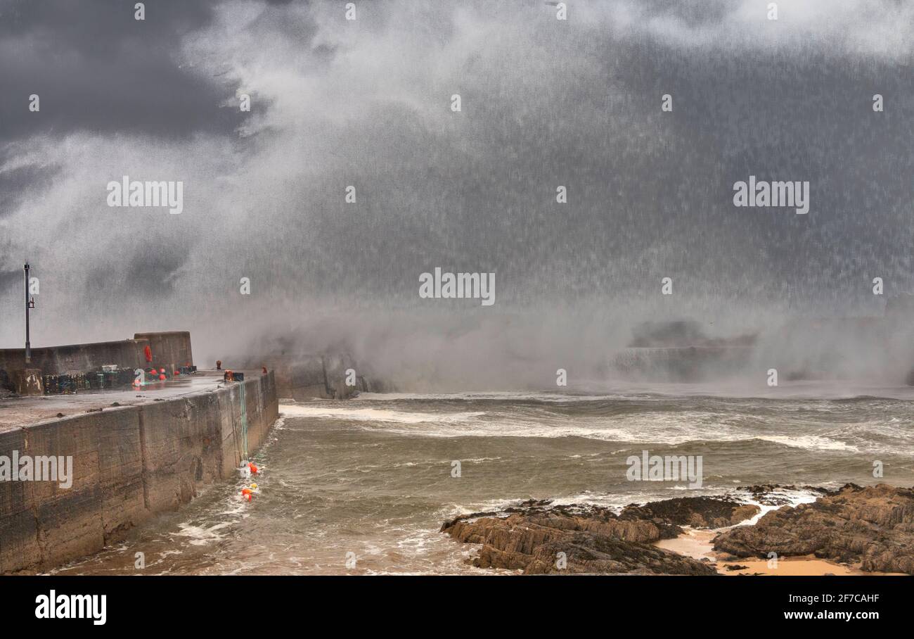 PORTKNOCKIE MORAY COAST SCOTLAND SCHWERER STURM UND SEHR STARKE WINDE MASSIVE WELLEN UND SPRÜHNEBEL BRECHEN ÜBER DEN HAFENMAUERN Stockfoto