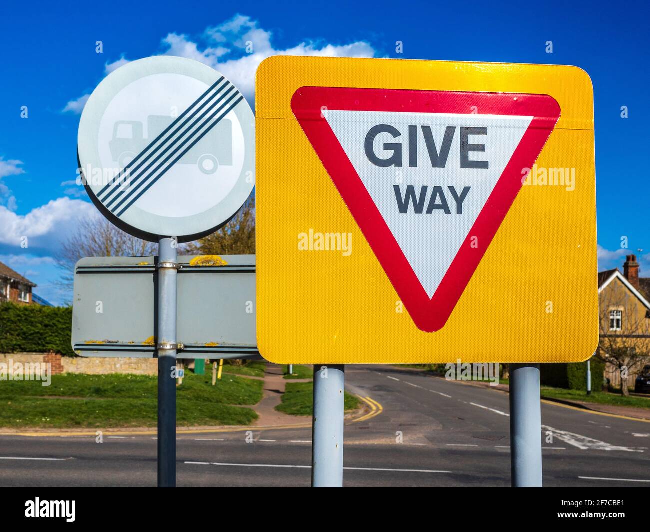 Give Way Sign UK - Give Way Zeichen auf einem gut sichtbaren gelben Hintergrund. Stockfoto