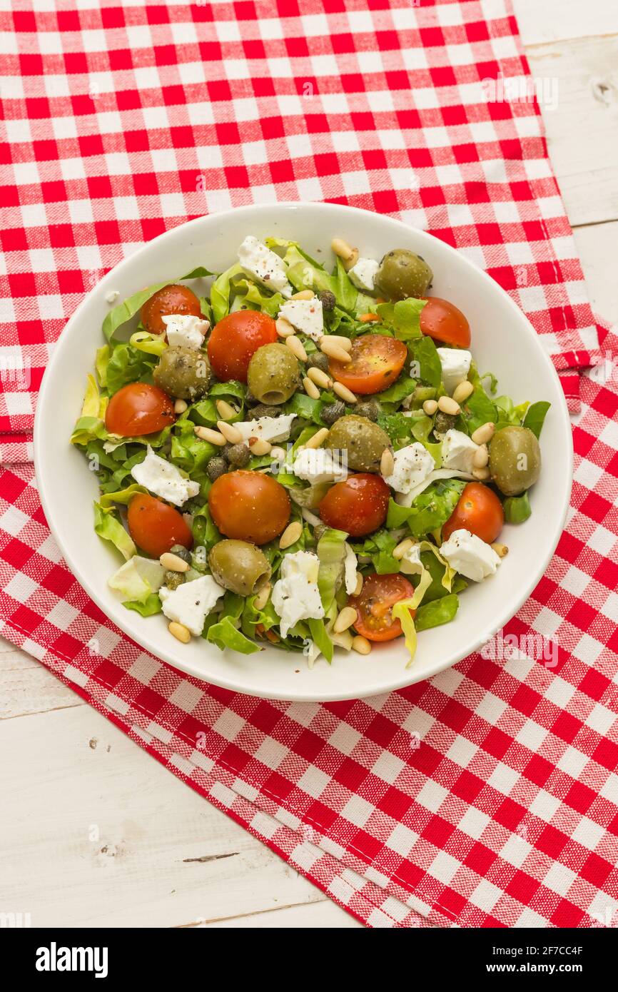 Draufsicht auf einen Sesam mit Salat, Kirschtomaten, grünen Oliven, Kapern und griechischem Feta Stockfoto