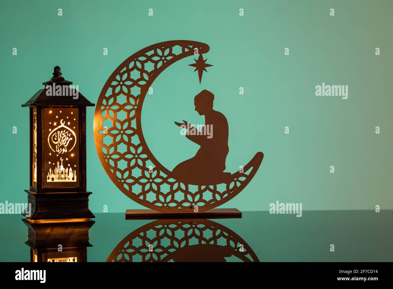 Eid Mubarak Konzepte mit Lampe eingeschrieben mit arabischem Text ins englische übersetzt als Ramadhan ist unser Licht., mit Halbmond in Silhouette Stockfoto