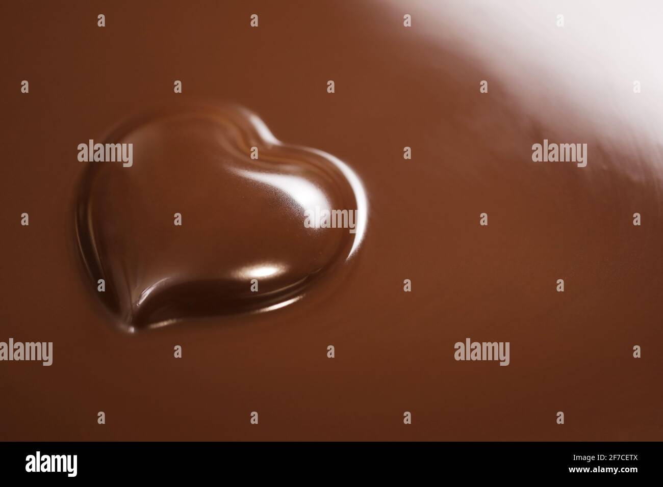 Eine herzförmige Schokolade im Schokoladenhintergrund Stockfoto
