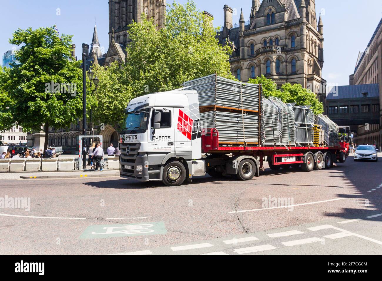 Ein Mercedes-Benz Actros 1844-Lkw transportiert einen flachen Sattelauflieger mit tragbaren Massenkontrollbarrieren vom Albert Square in Manchester weg. Stockfoto