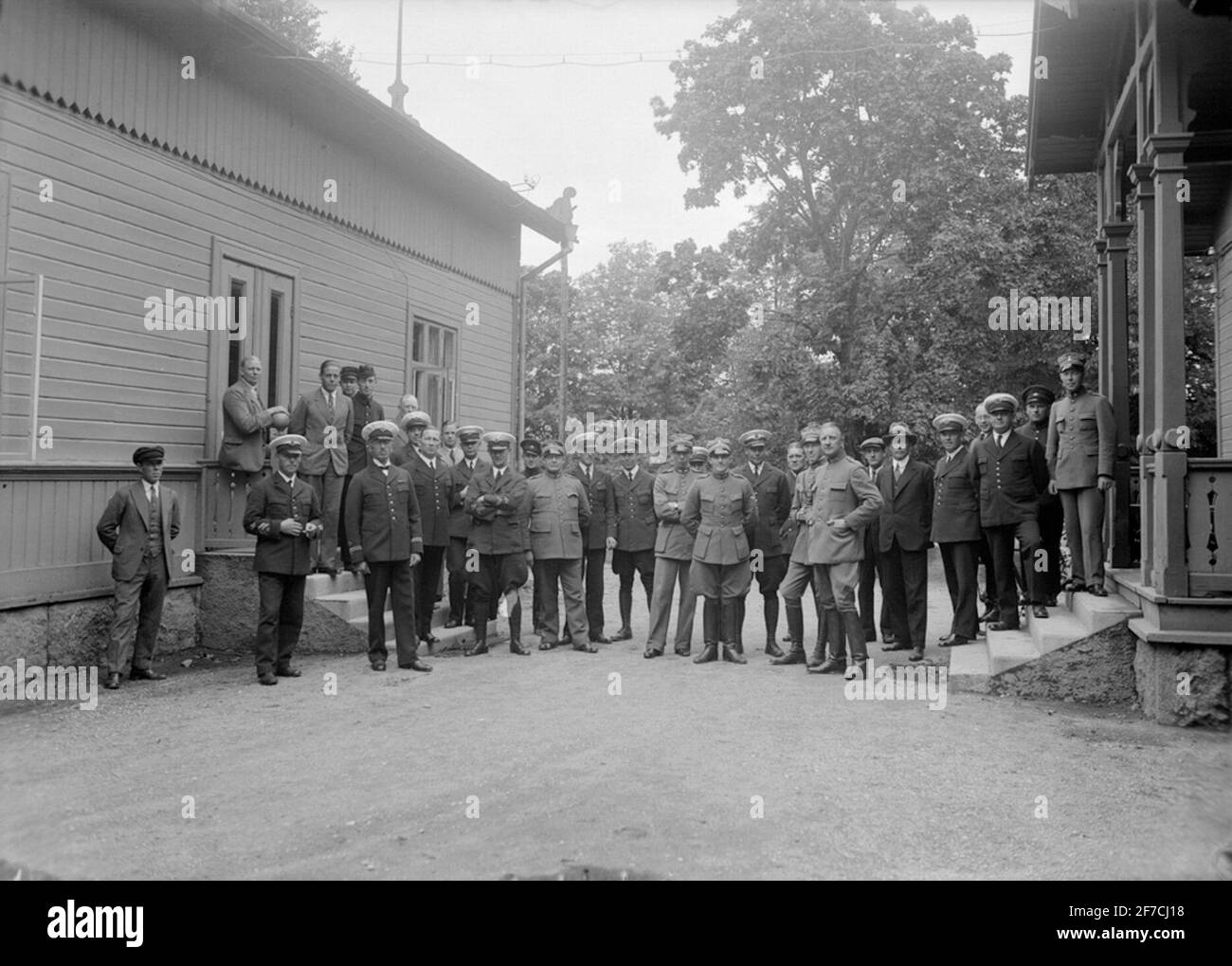 Gruppengericht, 3. Flüge nach Kriegsrecht Gruppenportrait. Mitarbeiter des dritten Fluges im Kriegsgebiet bei Malmen 1934-08-31. Männer zwischen zwei Gebäuden. Stockfoto