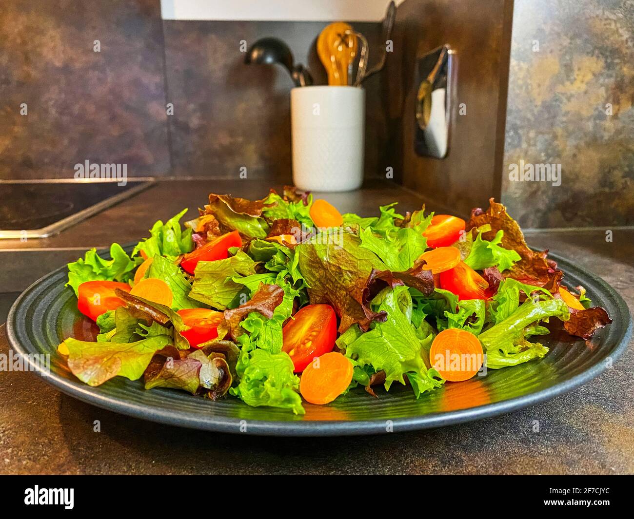 Teller mit frischem Salat aus Salat, Tomaten und Karotten. Stockfoto