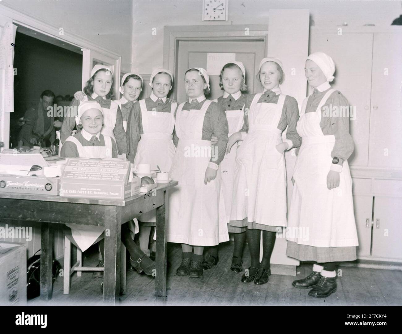 Porträtfotografie des Küchenpersonals bei F 19 . Porträtfotografie von Küchenmitarbeitern bei F 19, schwedischer Freiwilliger in Finnland. Acht finnische förplägnadslottor..frå links: Aili Virtanen (sitzend), Vosthenko, Unbekannt, Lucia Kusmin, Helga Karvo, Sylvi Lehto (geb. Lähdevio), Aino Aalto und Ellen Pörhön (geb. Rousu). Stockfoto