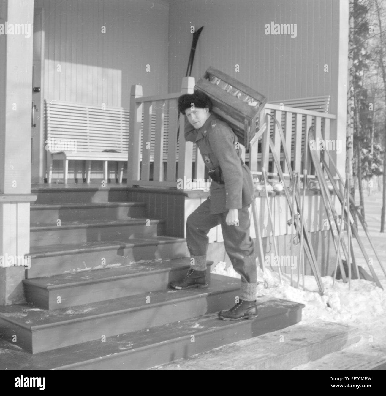 F 19, eine mit dem Militär verbundene schwedische NGO in Finnland, geht eine Treppe hinauf Motiv: Eine mit dem Militär verbundene schwedische NGO in Finnland, F 19 geht eine Treppe hinauf, die einen Rücken mit Flaschen trägt. Stockfoto