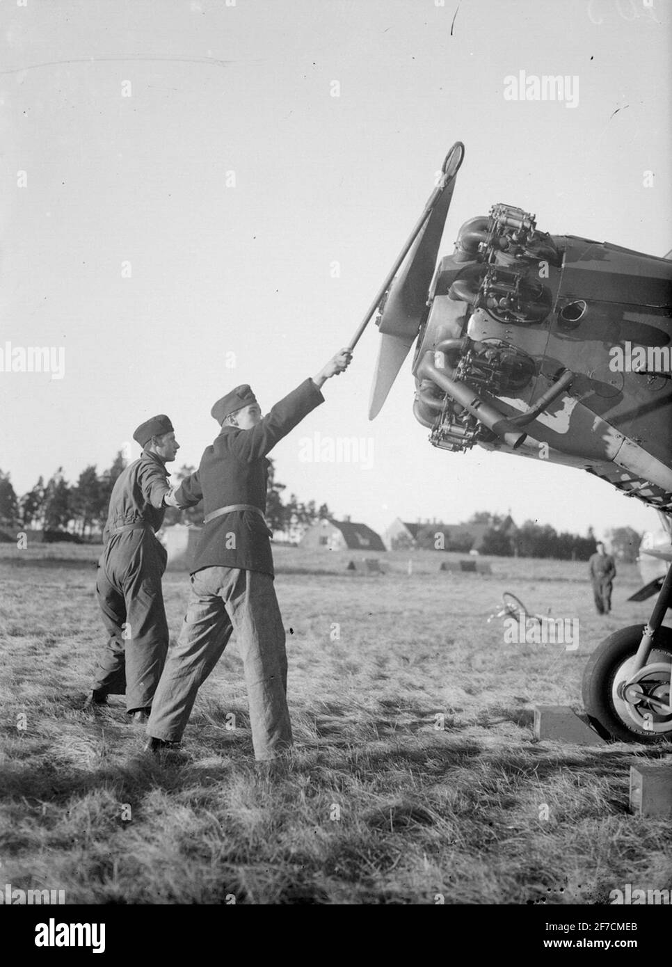 Start des Flugzeugmotors Start des Flugzeugmotors mit Gurt. Zwei Militärangehörige bei Flugzeugpropellern. Stockfoto