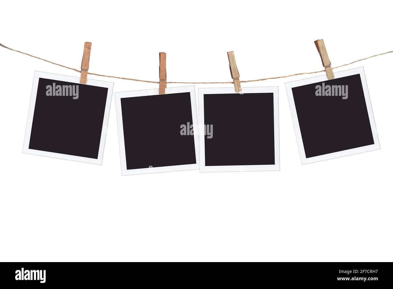 Vier leere Instant-Bilderrahmen, die an einem Seil hängen, isoliert auf weißem Hintergrund Stockfoto