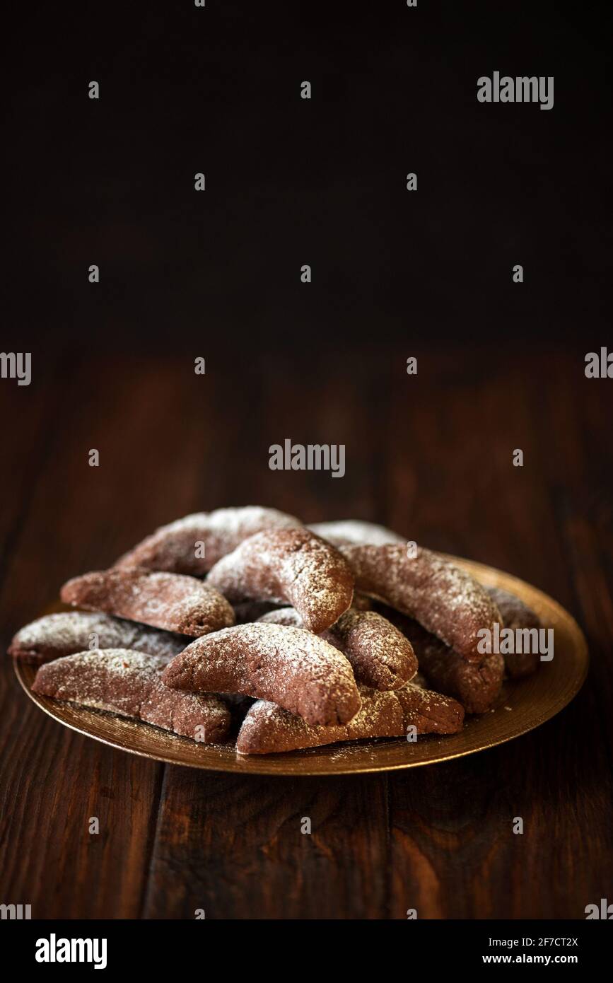 Hausgemachte Nüsse Cookies Schokolade Halbmond mit Zuckerpulver auf braunem Holzhintergrund. Speicherplatz kopieren. Weichfokus Stockfoto