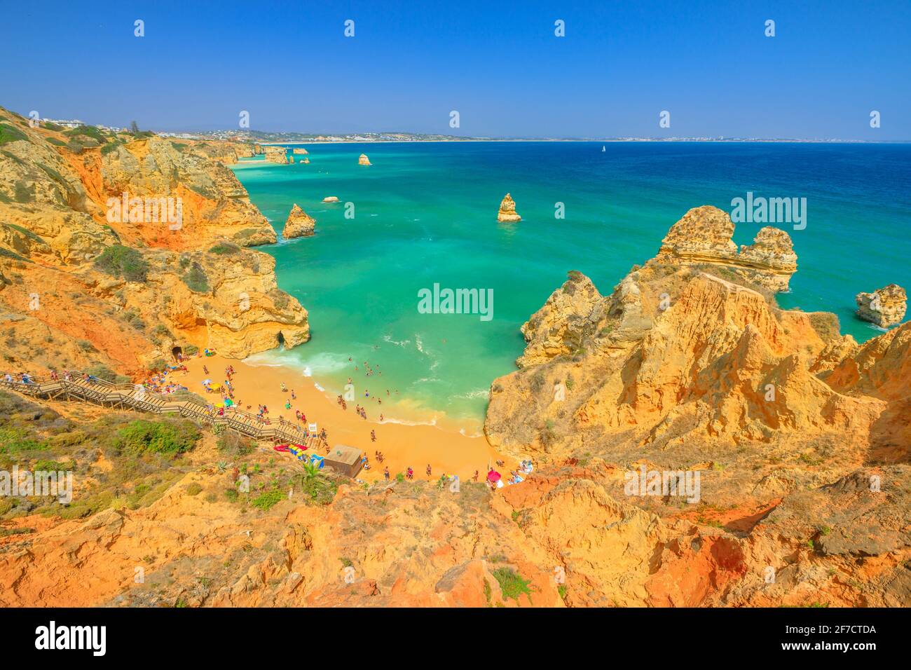 Luftaufnahme von Praia do Camilo mit langen Stufen und Lagos Küste an der Algarve, Portugal, Europa. Türkisfarbenes Wasser zwischen Felsformationen und Säulen Stockfoto