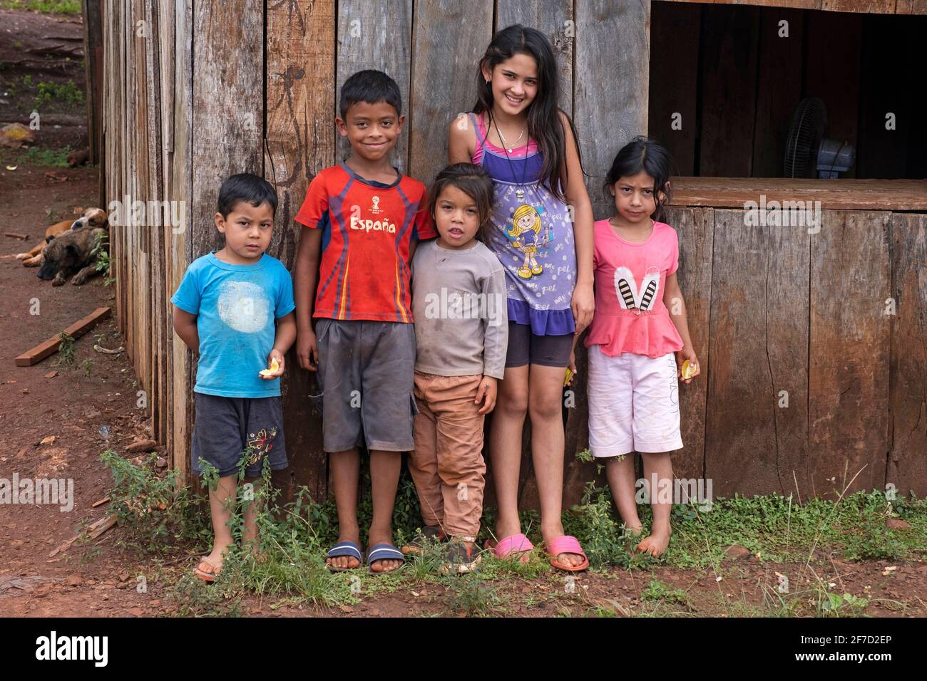 Paraguayische Kinder posieren vor einem primitiven Holzhaus in der Stadt Edelira im ländlichen Itapúa, Paraguay Stockfoto