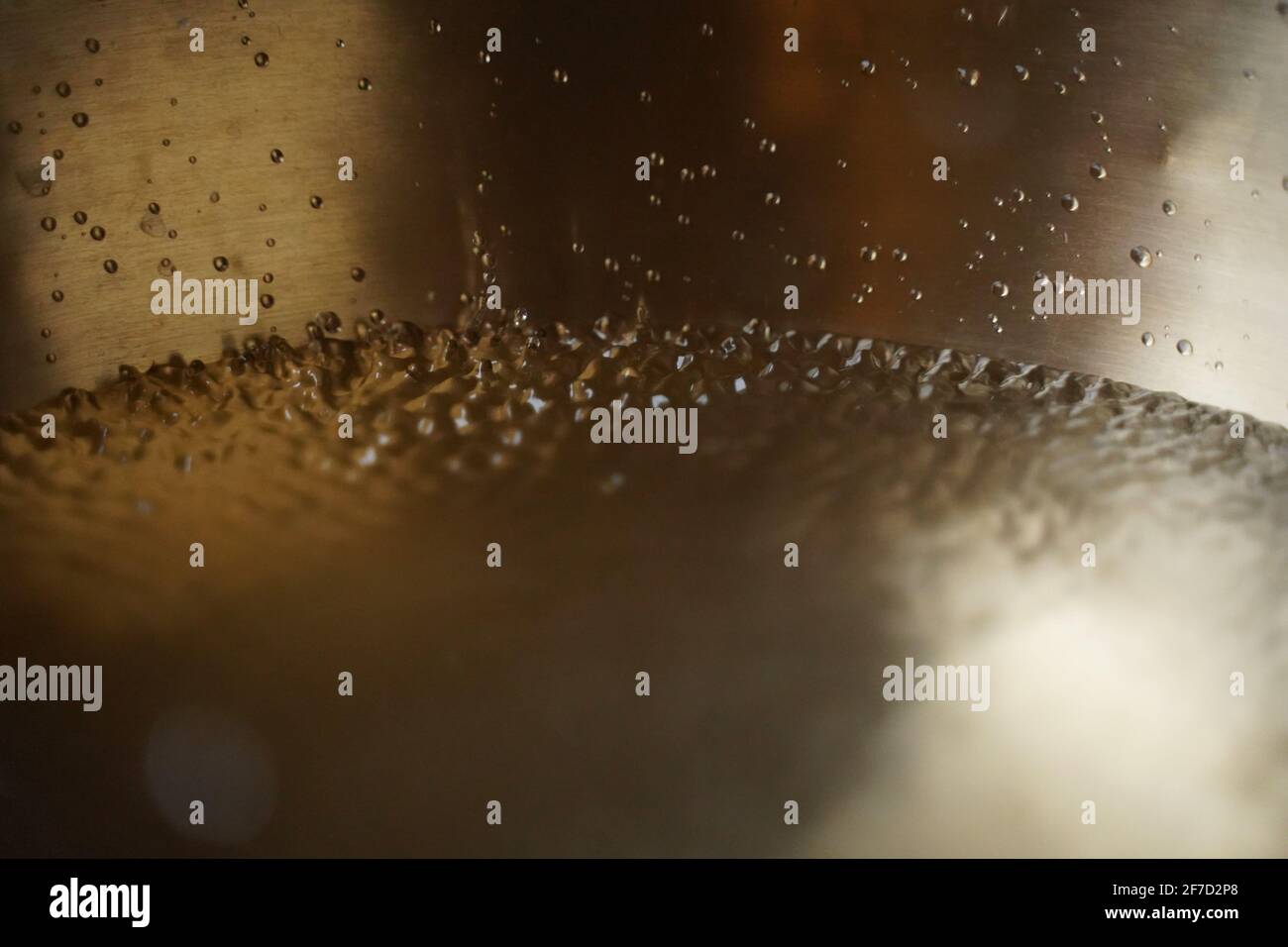 Tibetische Klangschale voller Wasser, Nahaufnahme von Wassertropfen, Klangheilungsinstrument Stockfoto