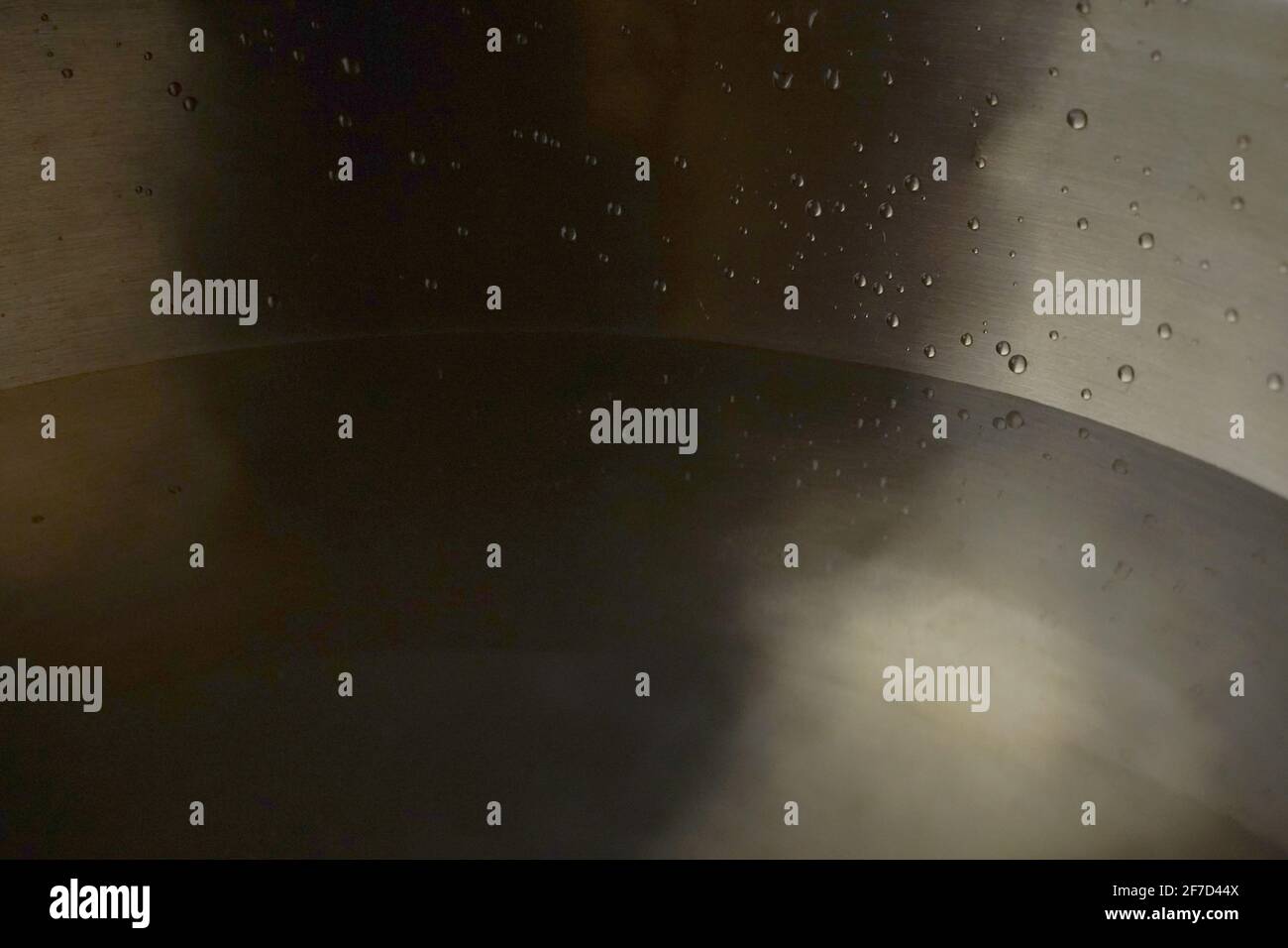 Tibetische Klangschale voller Wasser, Nahaufnahme von Wassertropfen, Klangheilungsinstrument Stockfoto