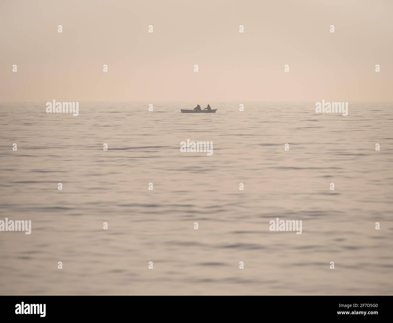 Vintage-Bild mit einem kleinen Fischerboot auf dem Meer. Einsames Boot mitten im Schwarzen Meer Stockfoto