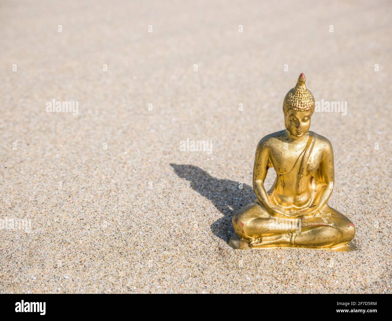 Kleine goldene buddha-Statue oder Buddharupa im Sand Stockfoto