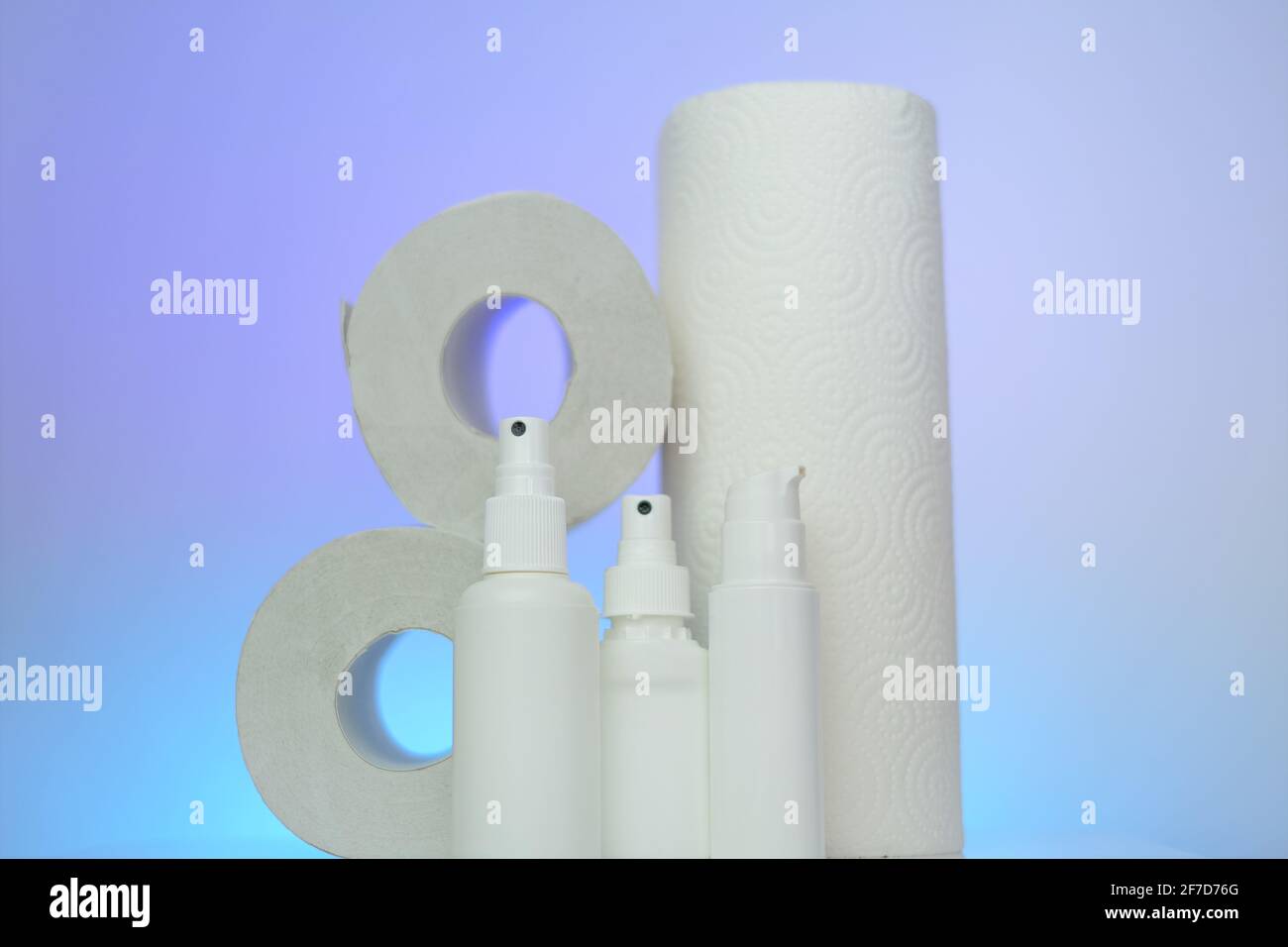 Hygiene und Hygiene . Toilettenpapier, Servietten und antibakteriell in Flaschen auf blauem verschwommenem Hintergrund.antibakterielle Flüssigkeiten in weißen Flaschen Stockfoto