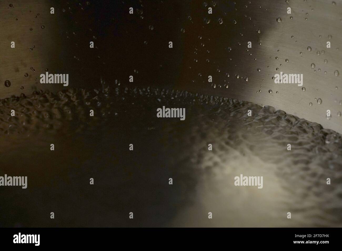 Tibetische Klangschale voller Wasser, Nahaufnahme von Wassertropfen, Klangheilungsinstrument Stockfoto