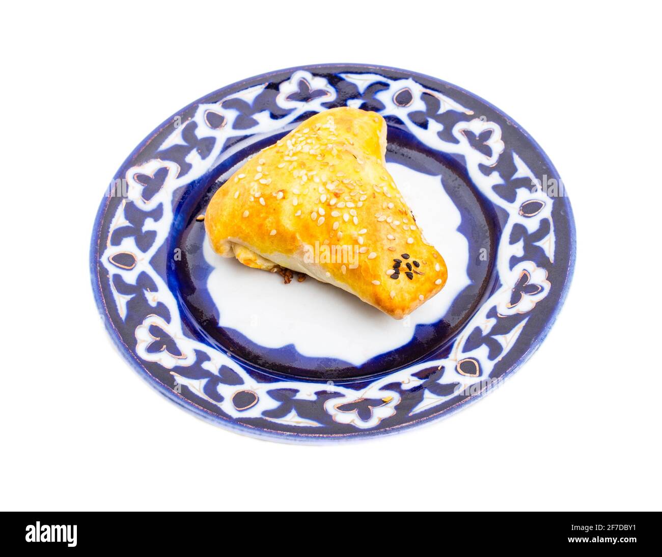 Traditionelles usbekisches samsa-Brötchen mit gehacktem Lamm. Serviert auf einem authentischen orientalischen Teller. Isoliert auf weißem Hintergrund. Stockfoto