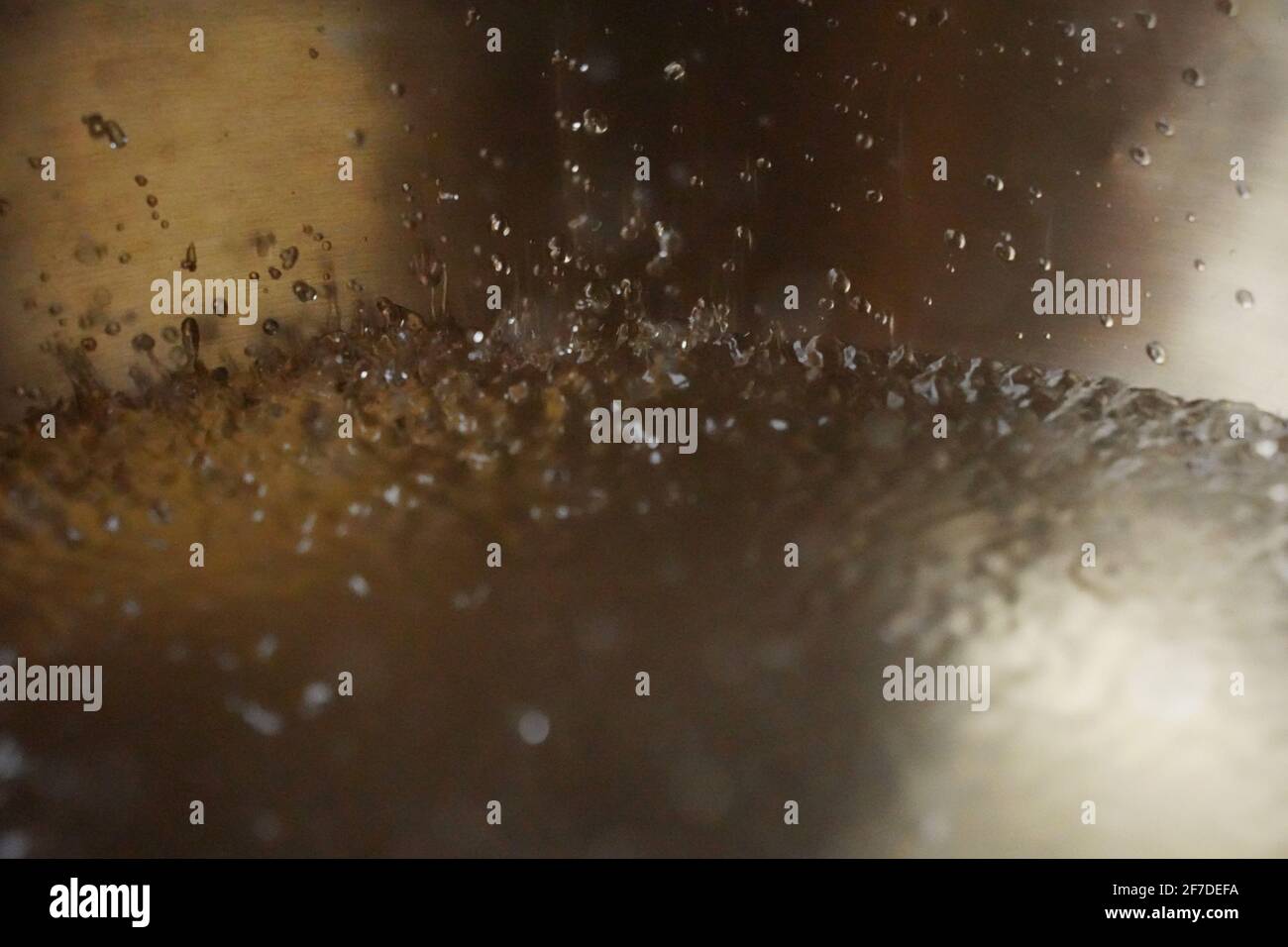Tibetische Klangschale voller Wasser, Nahaufnahme von Wassertropfen, Klangheilungsinstrument Stockfoto
