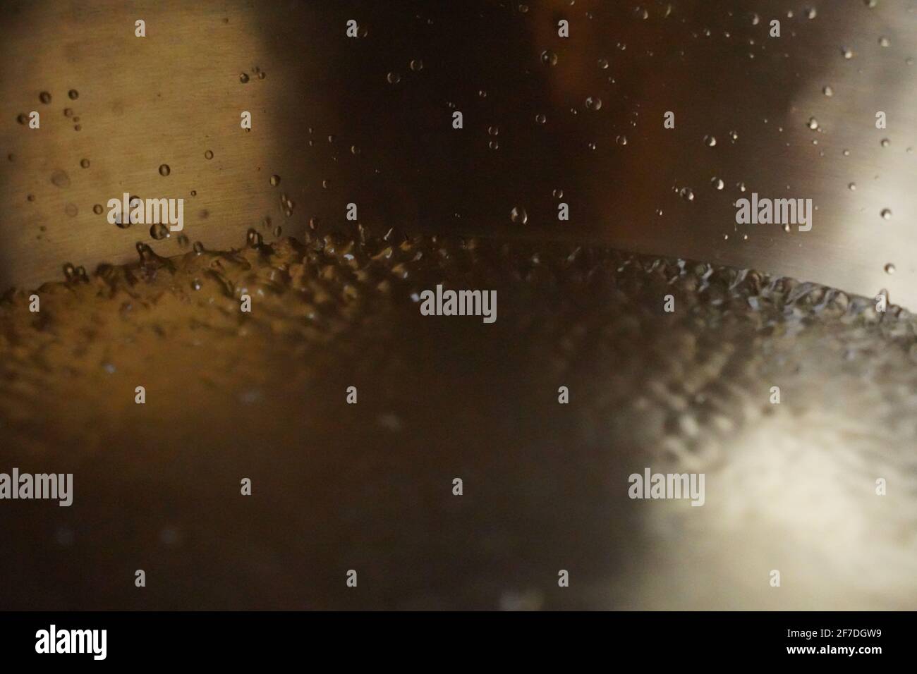 Tibetische Klangschale voller Wasser, Nahaufnahme von Wassertropfen, Klangheilungsinstrument Stockfoto