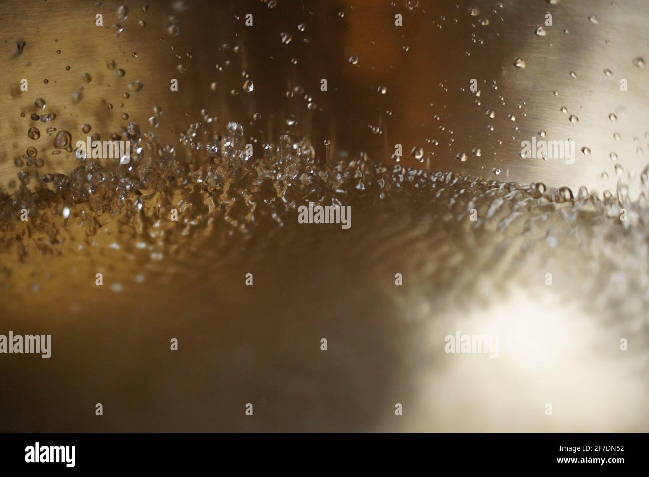 Tibetische Klangschale voller Wasser, Nahaufnahme von Wassertropfen, Klangheilungsinstrument Stockfoto