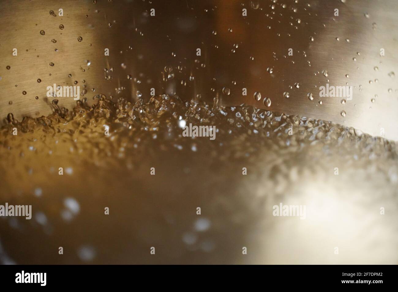 Tibetische Klangschale voller Wasser, Nahaufnahme von Wassertropfen, Klangheilungsinstrument Stockfoto