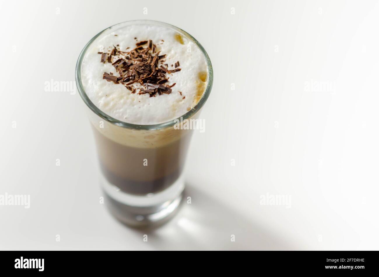 Kaffeegetränk, mit einer nussigen Note mit flauschigem Milchschaum, verziert mit Schokoladenspan, süßem Getränk Stockfoto