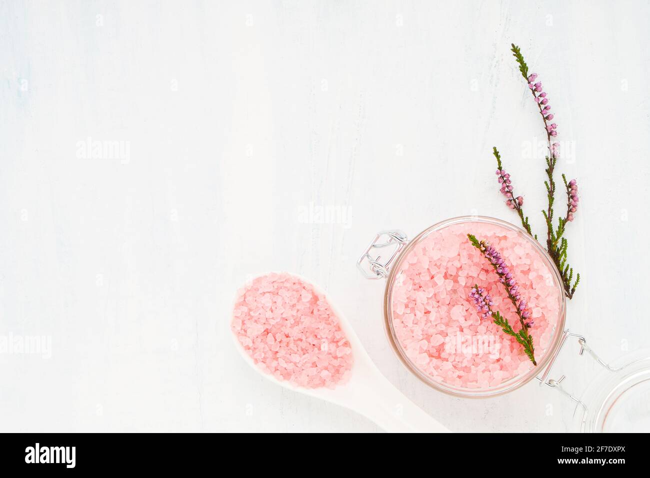 Rosa Aroma Badesalz in einem Glas auf hellem Hintergrund. Spa, Hautpflegekonzept. Draufsicht, Kopierbereich. Selektiver Fokus Stockfoto
